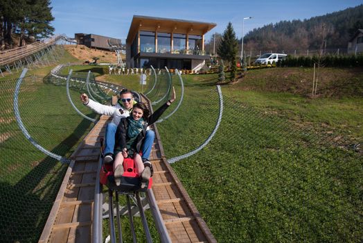 Excited young couple enjoys driving on alpine coaster