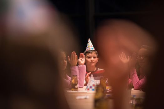 The young boy joyfully celebrating his birthday with a group of his friends