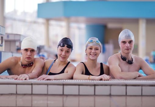 happy teen  group  at swimming pool class  learning to swim and have fun