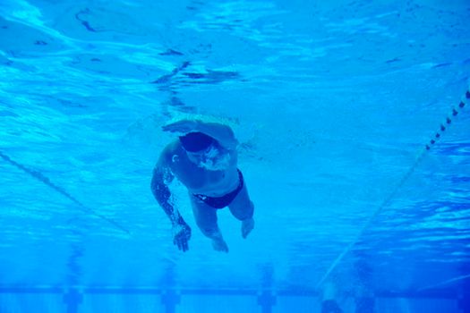 undervater shoot of swimming pool with good looking young swimmer 