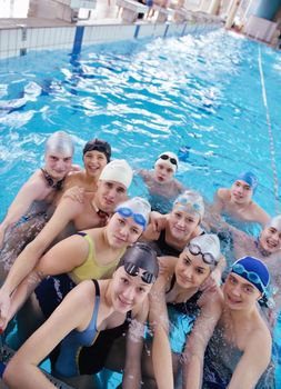 happy teen  group  at swimming pool class  learning to swim and have fun