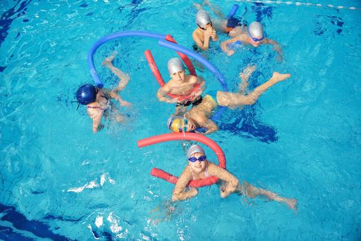 happy children kids group  at swimming pool class  learning to swim