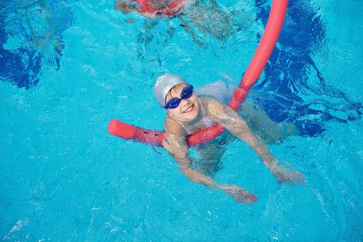 happy children kids group  at swimming pool class  learning to swim