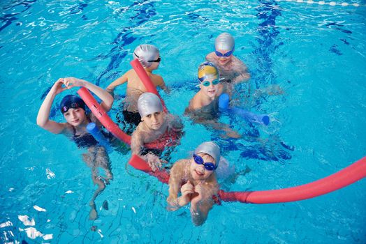 happy children kids group  at swimming pool class  learning to swim