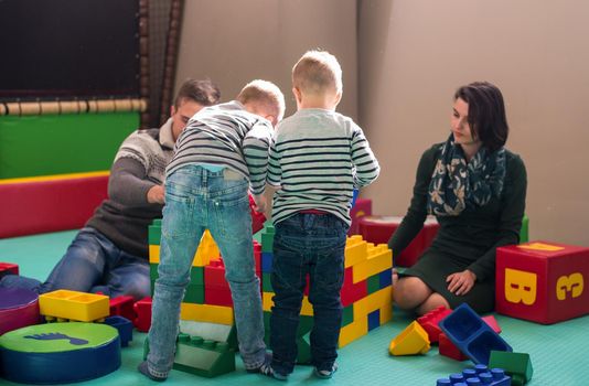 happy family enjoying free time young parents and kids having fun while playing together at childrens playroom