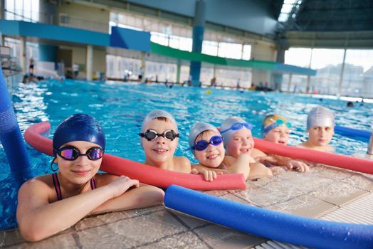 happy children kids group  at swimming pool class  learning to swim