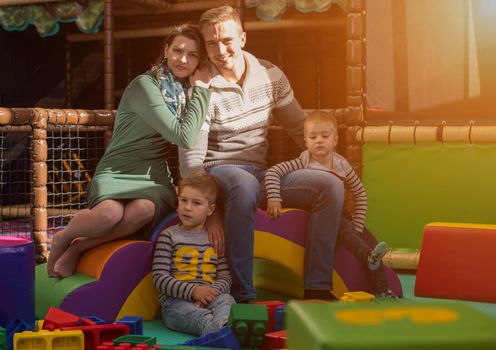 happy family enjoying free time young parents and kids having fun while playing together at childrens playroom