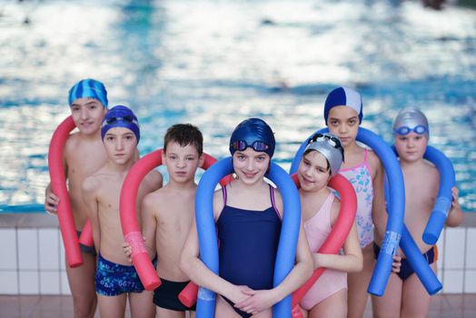 happy children kids group  at swimming pool class  learning to swim