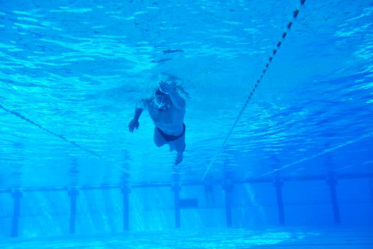 undervater shoot of swimming pool with good looking young swimmer 