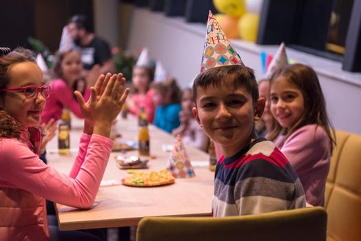 The young boy joyfully celebrating his birthday with a group of his friends