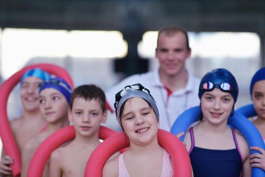 happy children kids group  at swimming pool class  learning to swim