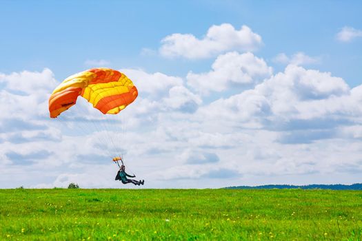 Skutech, Czech Republic, 6 August 2020: Landing of a parachutist on a grassy field. Parachute jumping. Skydiving.