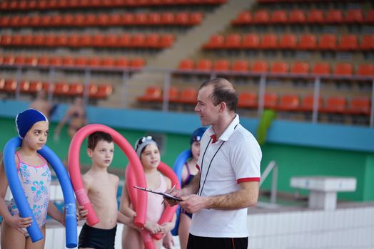 happy children kids group  at swimming pool class  learning to swim