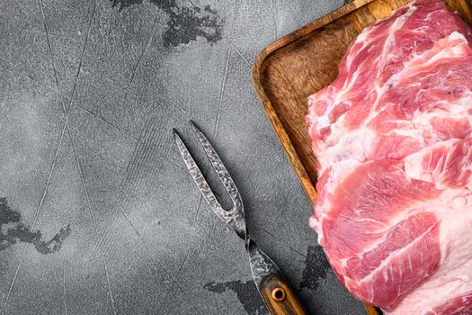 Raw pork neck meat piece for chop steak set, on gray stone table background, top view flat lay, with copy space for text