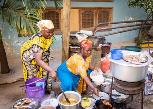 African woman cooking traditional food at street