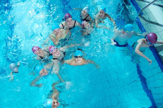 happy childrens group  at swimming pool class  learning to swim