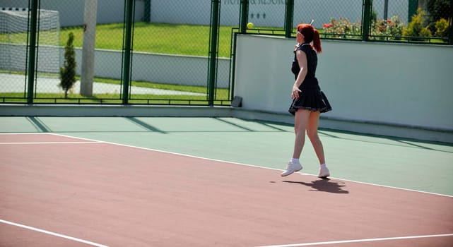 young fit woman play tennis outdoor on orange tennis field at early morning