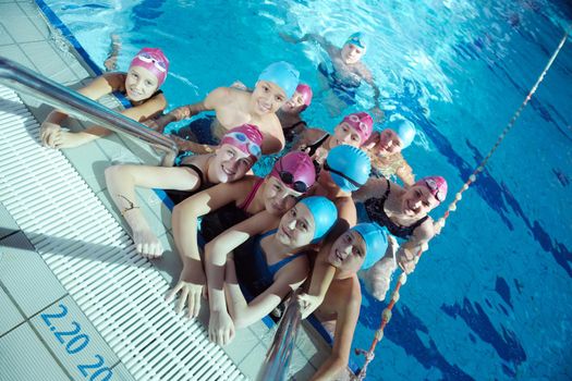 happy children kids group  at swimming pool class  learning to swim