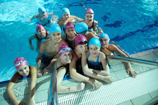 happy childrens group  at swimming pool class  learning to swim