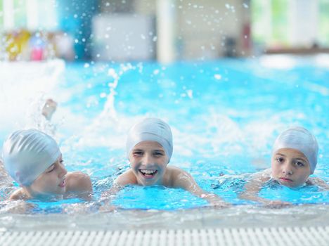 group of happy kids children   at swimming pool class  learning to swim