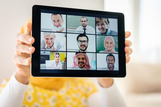 Muslim womah holding tablet with zoom conference screen