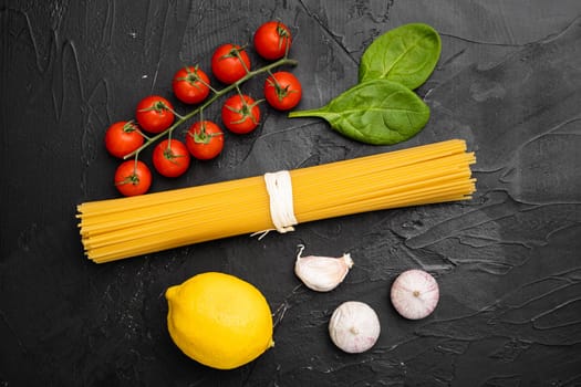 Spaghetti raw dry ingredients set, on black dark stone table background, top view flat lay