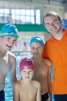 happy children kids group  at swimming pool class  learning to swim