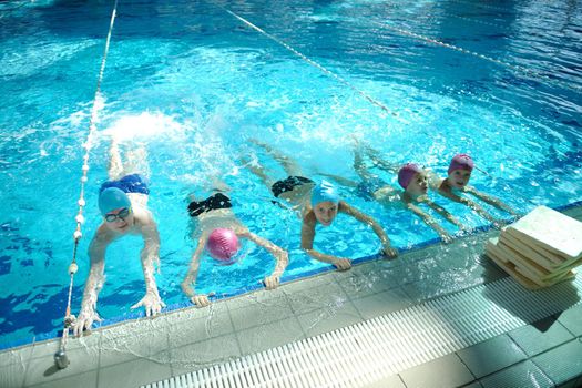 happy childrens group  at swimming pool class  learning to swim