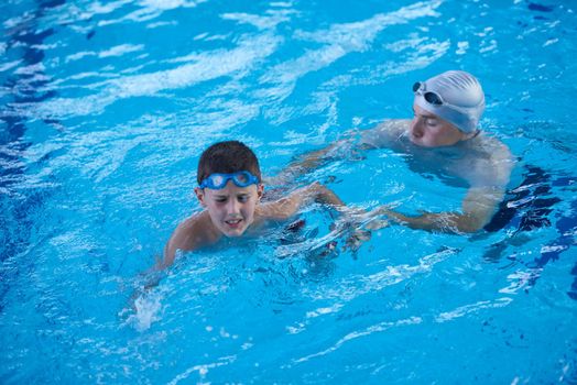 happy little child portrait on swimming school classes and recreation at indoor pool