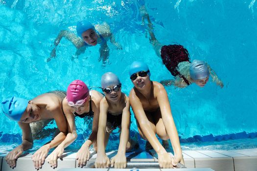 happy children kids group  at swimming pool class  learning to swim