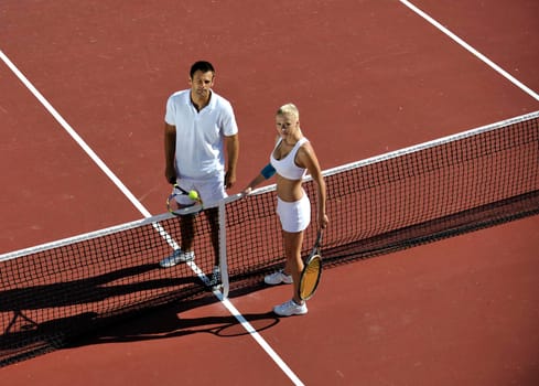 happy young couple play tennis game outdoor man and woman