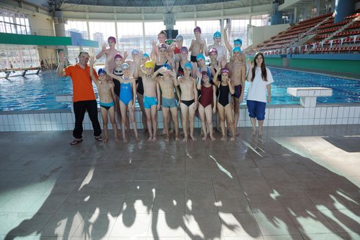 happy children kids group  at swimming pool class  learning to swim