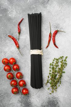 Squid ink black pasta with ingredients set, on gray stone table background, top view flat lay