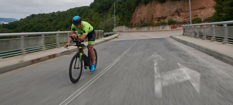 triathlon athlete riding racing bike on morning training urban enviroment