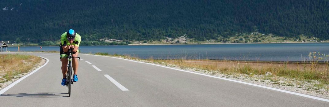 triathlon athlete riding professional racing bike at workout on curvy country road