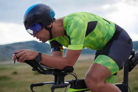 triathlon athlete riding professional racing bike at workout on curvy country road