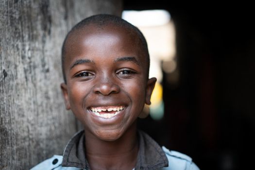 Cute happy poor black child at home