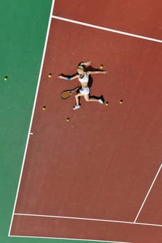 young fit woman play tennis outdoor on orange tennis field at early morning