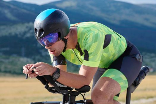 triathlon athlete riding professional racing bike at workout on curvy country road