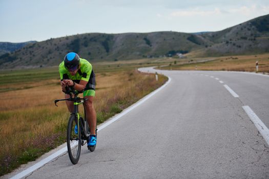 triathlon athlete riding professional racing bike at workout on curvy country road