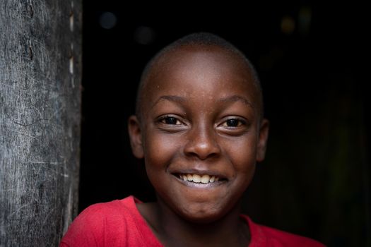 African black boy portrait standing near his poor house alone