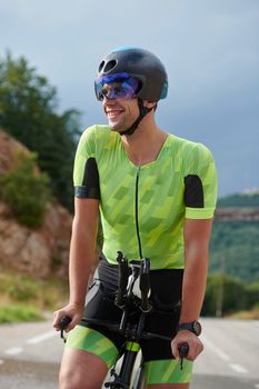 triathlon athlete riding professional racing bike at workout on curvy country road