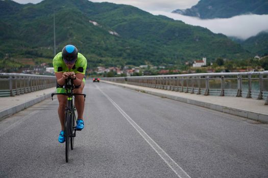 triathlon athlete riding racing bike on morning training urban enviroment