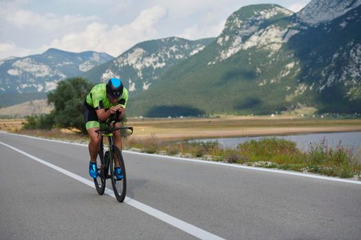 triathlon athlete riding professional racing bike at workout on curvy country road