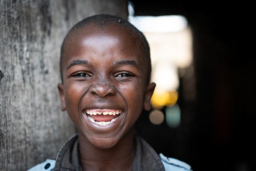 Cute happy poor black child at home