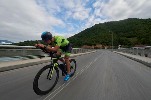 triathlon athlete riding racing bike on morning training urban enviroment