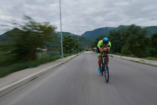 triathlon athlete riding racing bike on morning training urban enviroment