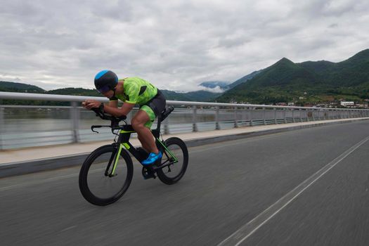 triathlon athlete riding racing bike on morning training urban enviroment