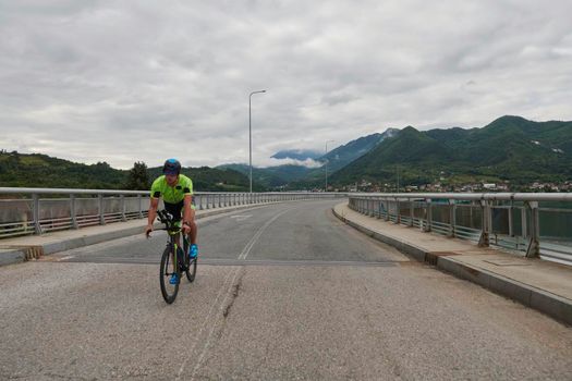triathlon athlete riding racing bike on morning training urban enviroment