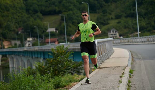 triathlon athlete running on street urban enviroment morning training workout